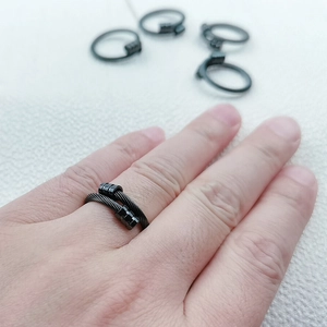 Détail d'une bague ajustable en acier inoxydable noir avec texture de fil industriel