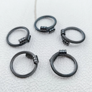 Détail de cinq bagues noires en câble d'acier inoxydable avec embout cylindrique ouvert