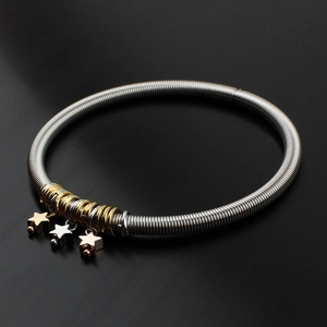 Guitar string spring bracelet with three-tone star charms on black background