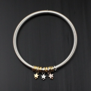 Detailed macro view of 4.2mm spring guitar string bracelet with tri-color star charms