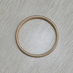 Makroaufnahme der roségoldenen Gitarrensaiten-Armreif mit Spiral-Federstruktur