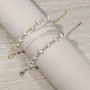 Minimalist chain bracelets with freshwater pearls in gold and silver finish on display