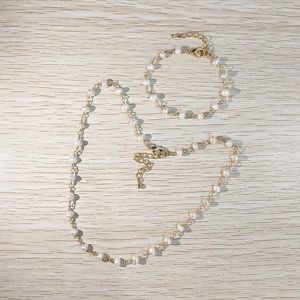 Minimalist gold chain necklace and bracelet set featuring natural white freshwater pearls