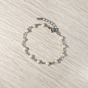 Macro detail of handmade freshwater pearl chain bracelet with adjustable silver lobster clasp