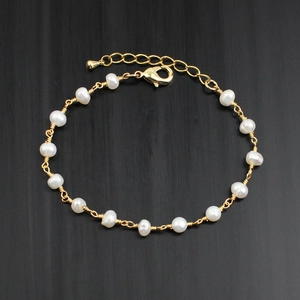 Detailed macro of white freshwater pearls and 14K gold-plated wire wrapped link chain
