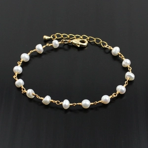Close-up of golden chain bracelet with natural white pearls and adjustable lobster clasp