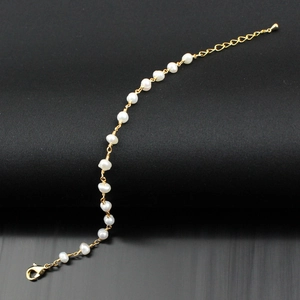 Close-up of a gold chain bracelet with irregular freshwater pearls and adjustable clasp