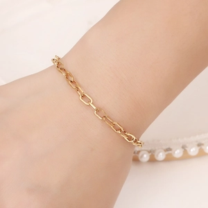Bracelet chaîne trombone minimaliste en acier inoxydable doré porté au poignet