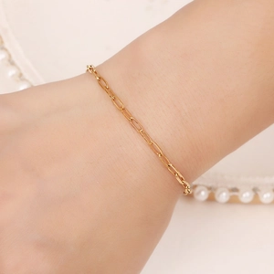Bracelet minimaliste en acier inoxydable doré à maillons trombones sur poignet