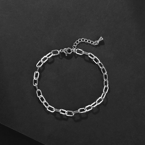 Minimalistische roestvrijstalen paperclip schakelarmband op een zwarte achtergrond