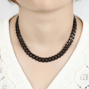 Grosse chaîne gourmette noire en acier inoxydable poli portée sur un cou de femme