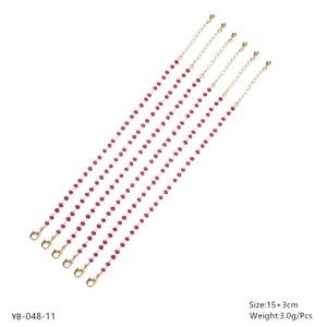 Detailed view of red beaded bracelets with gold lobster clasps and extension chains