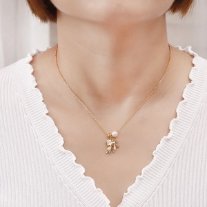 Elegante collana con ciondolo a pesce dorato e perla d'acqua dolce su una modella