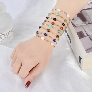 Dettaglio di bracciali multistrato in pietre naturali con catena placcata in oro 18K