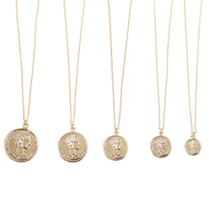 Five assorted sizes of rose gold Elizabeth II coin pendant necklaces on white backdrop