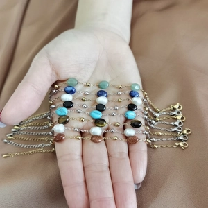Dettaglio di bracciali con perline placcati oro 18K con agata colorata e perle d'acqua dolce