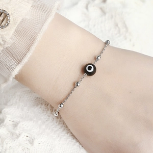 Silver evil eye bead bracelet with small metal balls on a delicate stainless steel chain