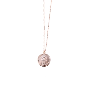 Close-up of rose gold coin pendant with Elizabeth II portrait and vintage relief detail