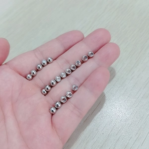 DIY 5mm stainless steel beads with center holes for jewelry making on a wooden desk