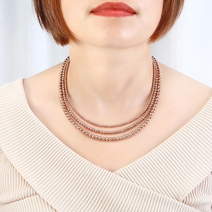 Three-layer layered rose gold bead necklace showing elegant drape on model's neck