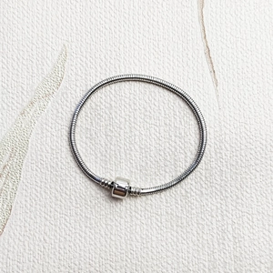 Dettaglio del bracciale a maglia serpente in acciaio lucido con chiusura a barilotto