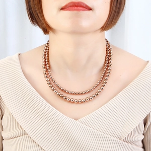 Elegant double-layered rose gold stainless steel bead necklace worn by a fashion model