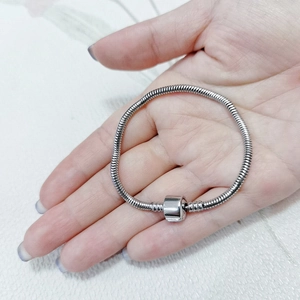 Dettaglio di un bracciale a maglia serpente in acciaio inossidabile con chiusura lucida
