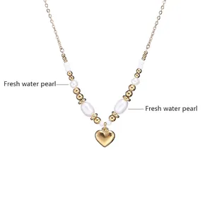 Détail d'un collier en or avec perles d'eau douce et pendentif cœur poli brillant