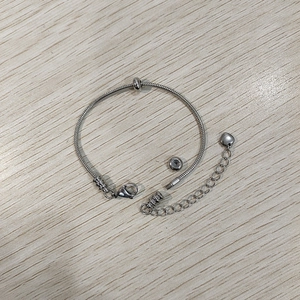 Dettaglio macro del bracciale a maglia serpente in acciaio inossidabile con cuore e chiusura