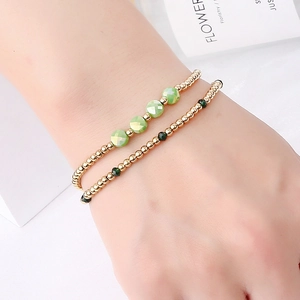 Detail of double-layer beaded bracelet with green crystals and gold stainless steel beads