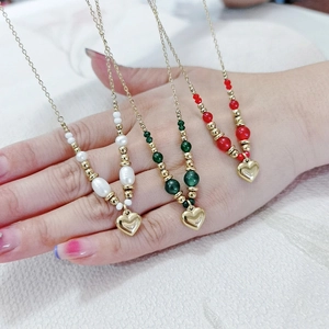 Détails des colliers coeur doré avec perles blanches et accents de perles vertes et rouges