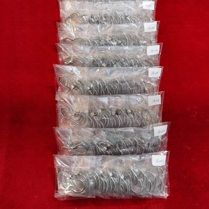 Dettaglio di bracciali a serpente argentati in bustine con etichette di misura 16 cm