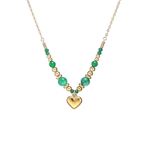 Détail du collier pendentif cœur avec chaîne dorée et perles vertes pour femme