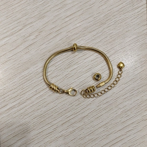 Dettaglio del bracciale a catena serpente dorata con ciondolo a cuore e terminale filettato
