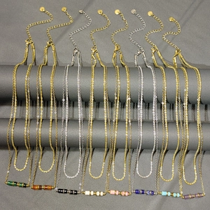 Dettaglio di otto collane in oro 18K e acciaio inossidabile con pietre naturali multicolori