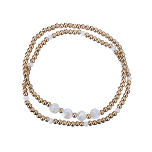 Detail of beaded stretch bracelet with gold stainless steel beads and white crystal accents