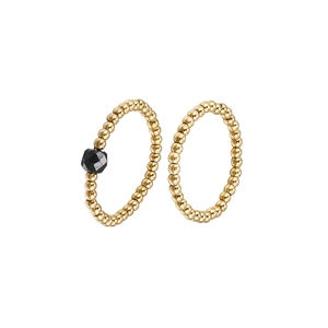 Detail of beaded gold-tone rings featuring a set with a faceted black gemstone accent