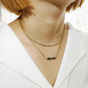Dettaglio della collana a due strati in acciaio inossidabile oro 18K con pietre di malachite