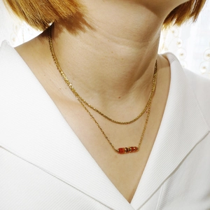 Dettaglio di una collana a doppio strato placcata oro 18K con pietre naturali arancioni