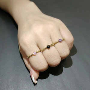 Macro detail of three beaded stainless steel rings with purple and black zircon stones