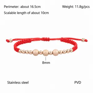 Macro detail of red braided cord bracelet with rose gold sandblasted stainless steel beads