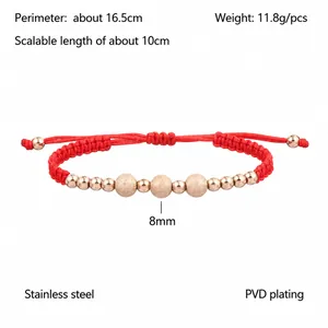 Dettaglio macro del bracciale in corda rossa intrecciata con perline in acciaio oro rosa
