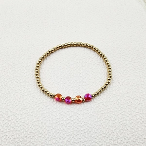 Detail of beaded bracelet with golden beads and colorful multifaceted crystal accents