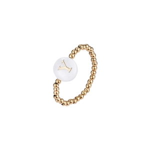 Detailed close-up of a gold-beaded elastic ring featuring a white shell charm with letter Y