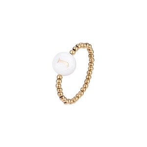 Close-up of golden beaded elastic ring with white shell charm featuring letter J
