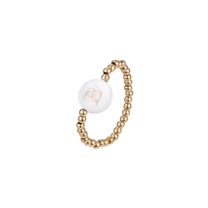 Detailed macro view of a gold beaded elastic ring with a white letter B shell inlay charm