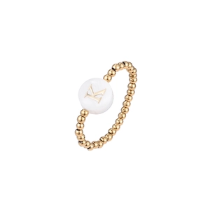 Macro shot of elastic gold beaded ring featuring a white round bead with golden letter K