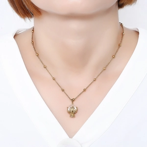 Elegante collana d'oro con pendente a calice di foglie e perla bianca su modella