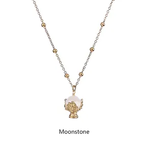 Dettaglio del pendente in pietra di luna con castone dorato su una collana a sfere