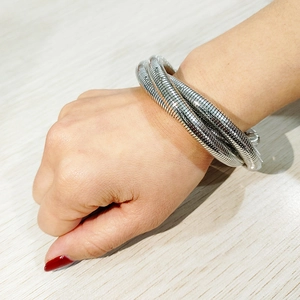 Brazalete de espiral multicapa en acero plateado pulido en una muñeca femenina